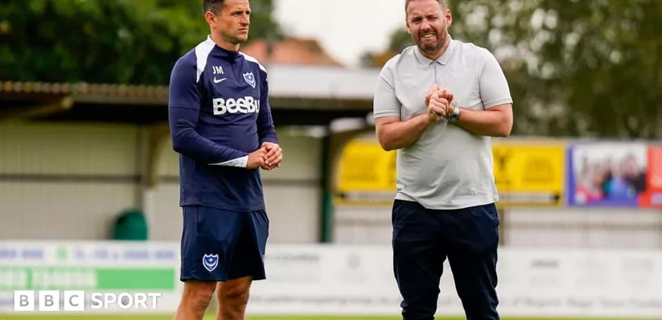 Entrenador y jugador conversando en el campo de entrenamiento