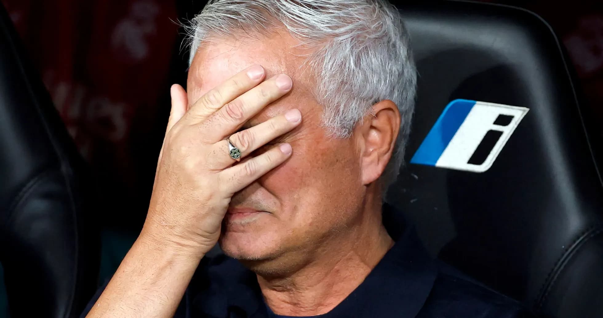 Entrenador con mano en la cara en el banquillo