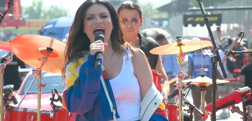 Cantante actuando con banda en evento al aire libre