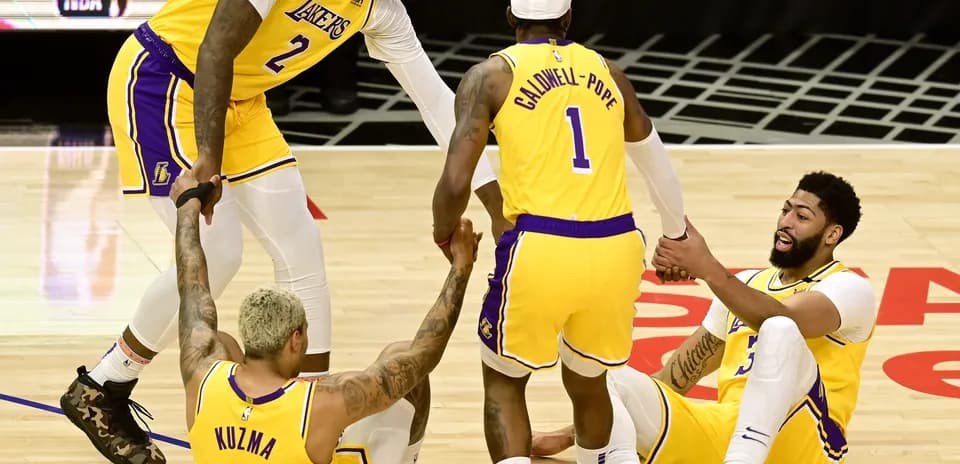 Jugadores de los Lakers ayudan a Kuzma y Davis en el suelo