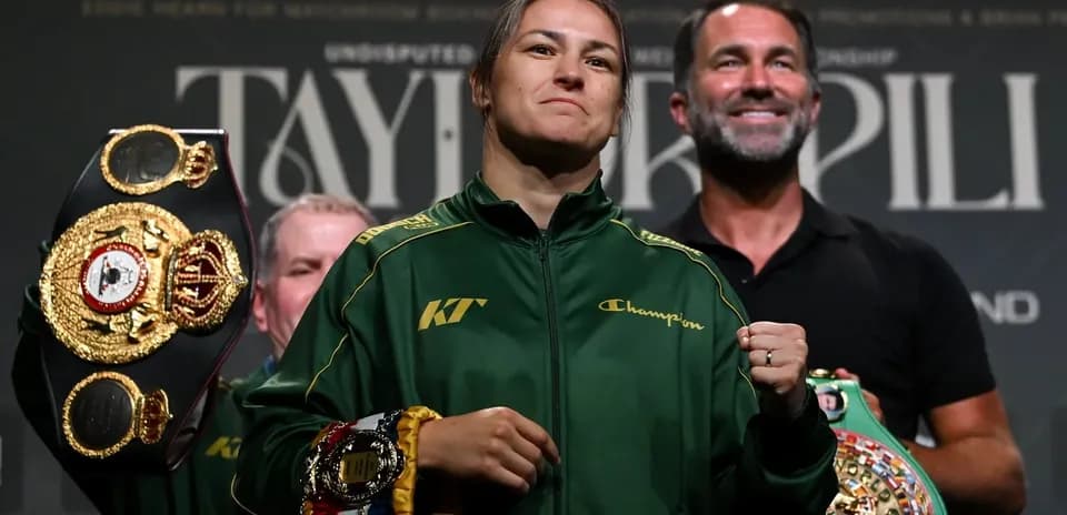 Boxeadora mostrando cinturones en conferencia de prensa