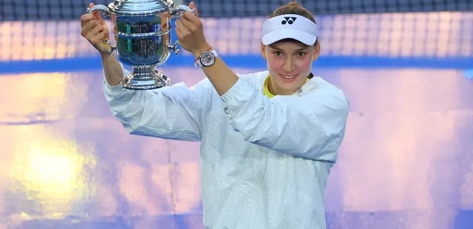 Jugadora levantando trofeo en cancha de tenis