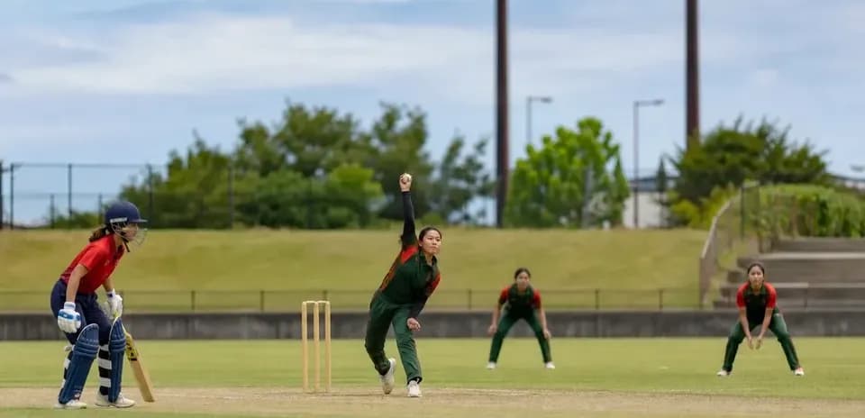 Jugadora lanzando durante un partido de cricket