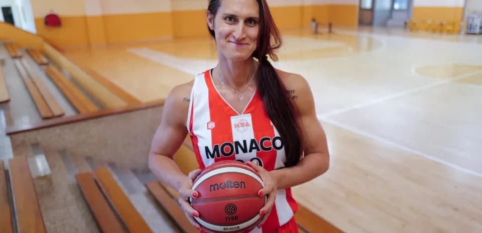 Jugadora de baloncesto sosteniendo un balón en cancha