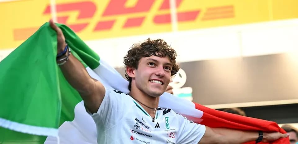 Piloto sosteniendo la bandera italiana en celebración