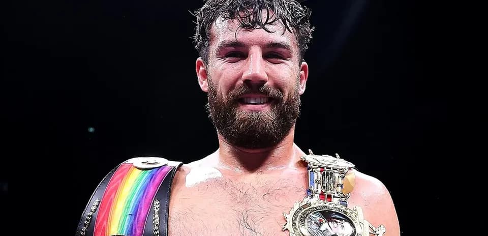 Boxeador sonriente con cinturones de campeón