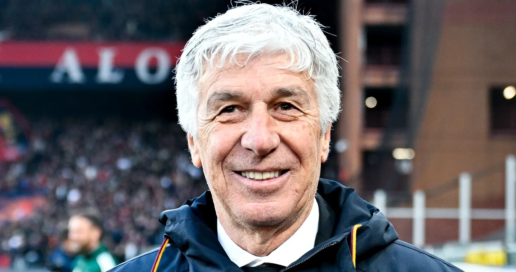 Entrenador sonriendo en el estadio durante el partido