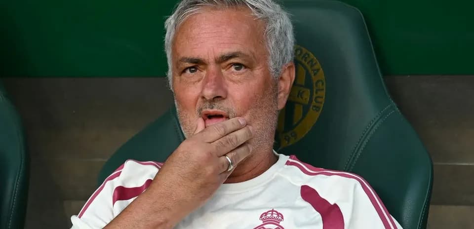 Entrenador sentado en el banquillo con expresión pensativa