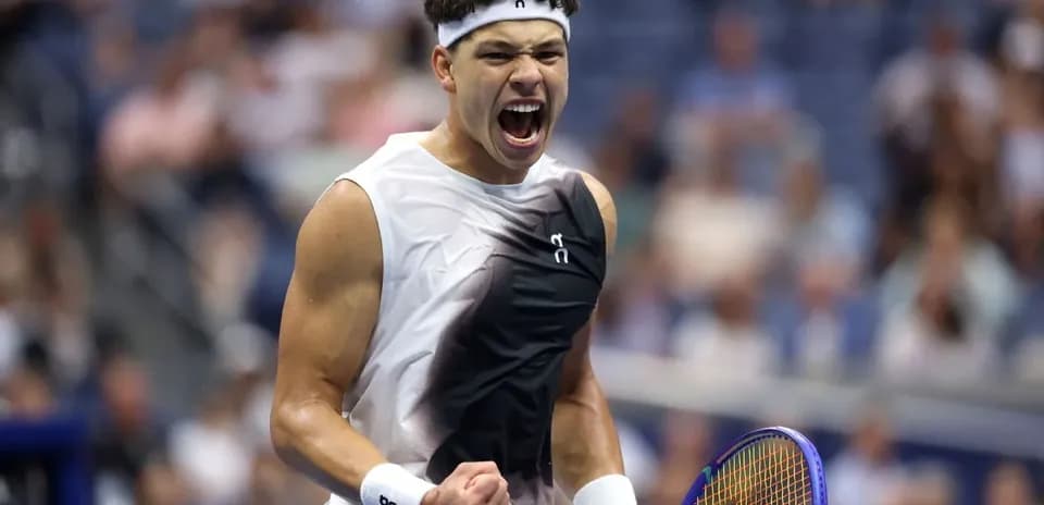 Jugador de tenis celebrando con raqueta en mano