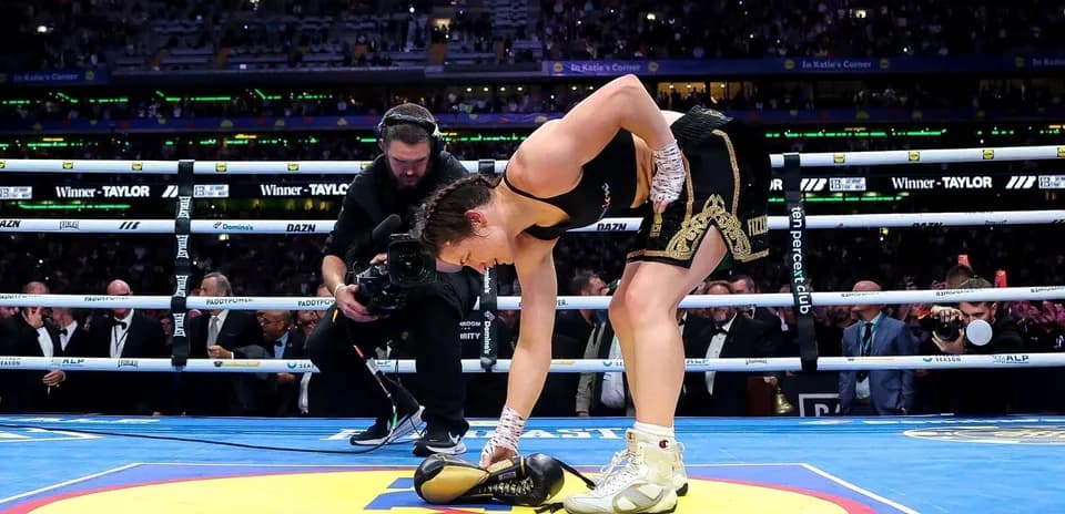 Boxeadora recogiendo sus guantes en el ring