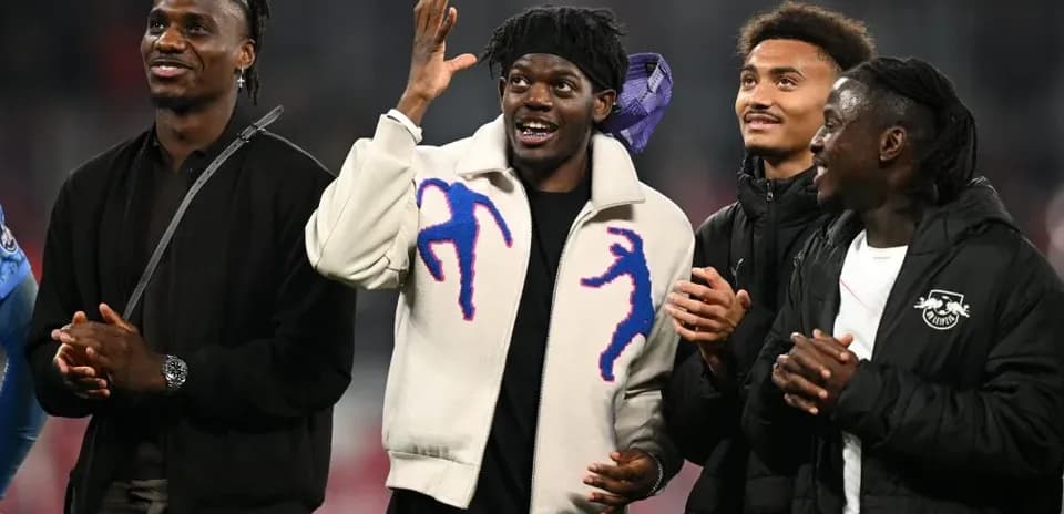 Cuatro jugadores sonriendo en el campo de fútbol