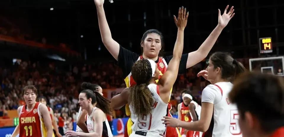 Jugadora china defendiendo mientras otra intenta anotar