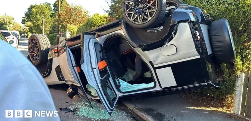 Coche volcado en la carretera con vidrios rotos