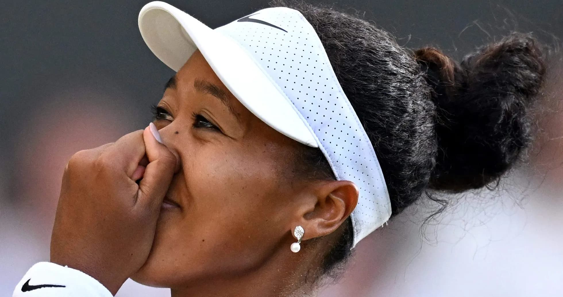 Jugadora de tenis con gorra y pendientes sonriendo Jugadora de tenis con gorra y pendientes sonriendo