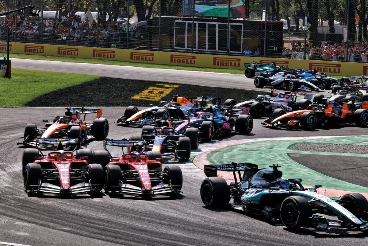 Varios coches de Fórmula 1 compitiendo en curva Varios coches de Fórmula 1 compitiendo en curva