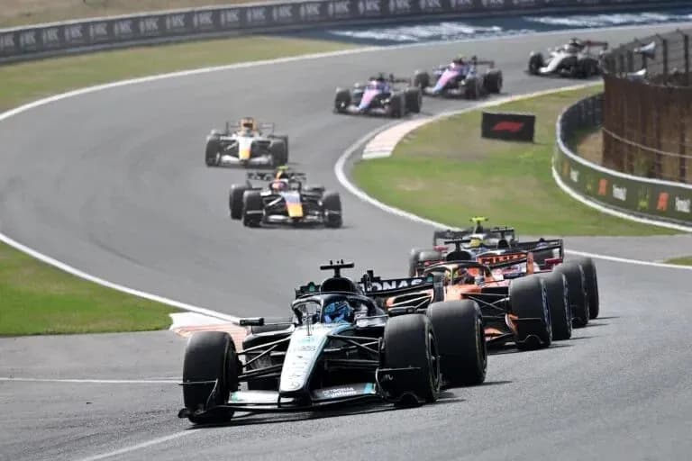 Varios coches de Fórmula 1 en una curva de pista Varios coches de Fórmula 1 en una curva de pista