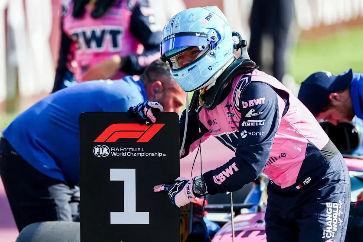 Piloto sosteniendo cartel de F1 en el paddock Piloto sosteniendo cartel de F1 en el paddock