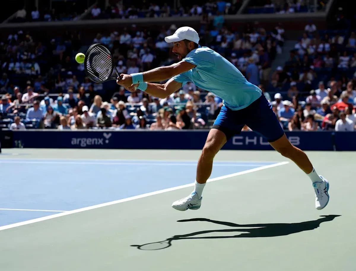 Jugador de tenis golpeando la pelota en la cancha Jugador de tenis golpeando la pelota en la cancha