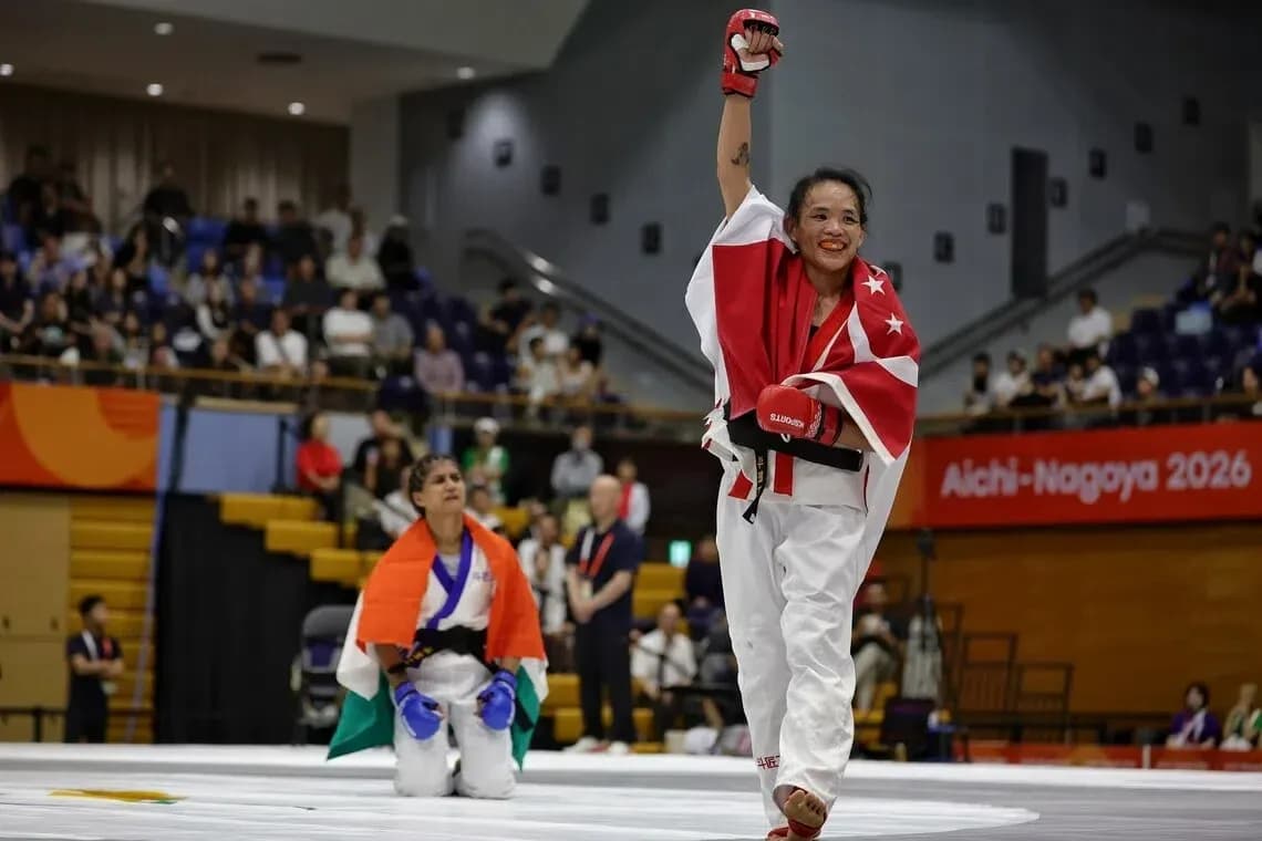 Competitor celebrating victory with raised fist in dojo Competitor celebrating victory with raised fist in dojo