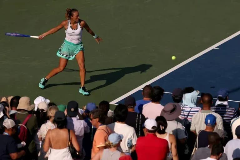 Jugadora golpeando la pelota durante un partido de tenis Jugadora golpeando la pelota durante un partido de tenis