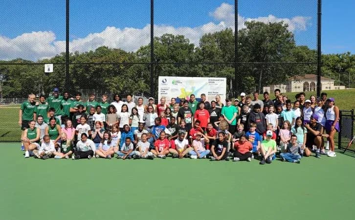 Grupo grande de personas en una cancha de tenis Grupo grande de personas en una cancha de tenis