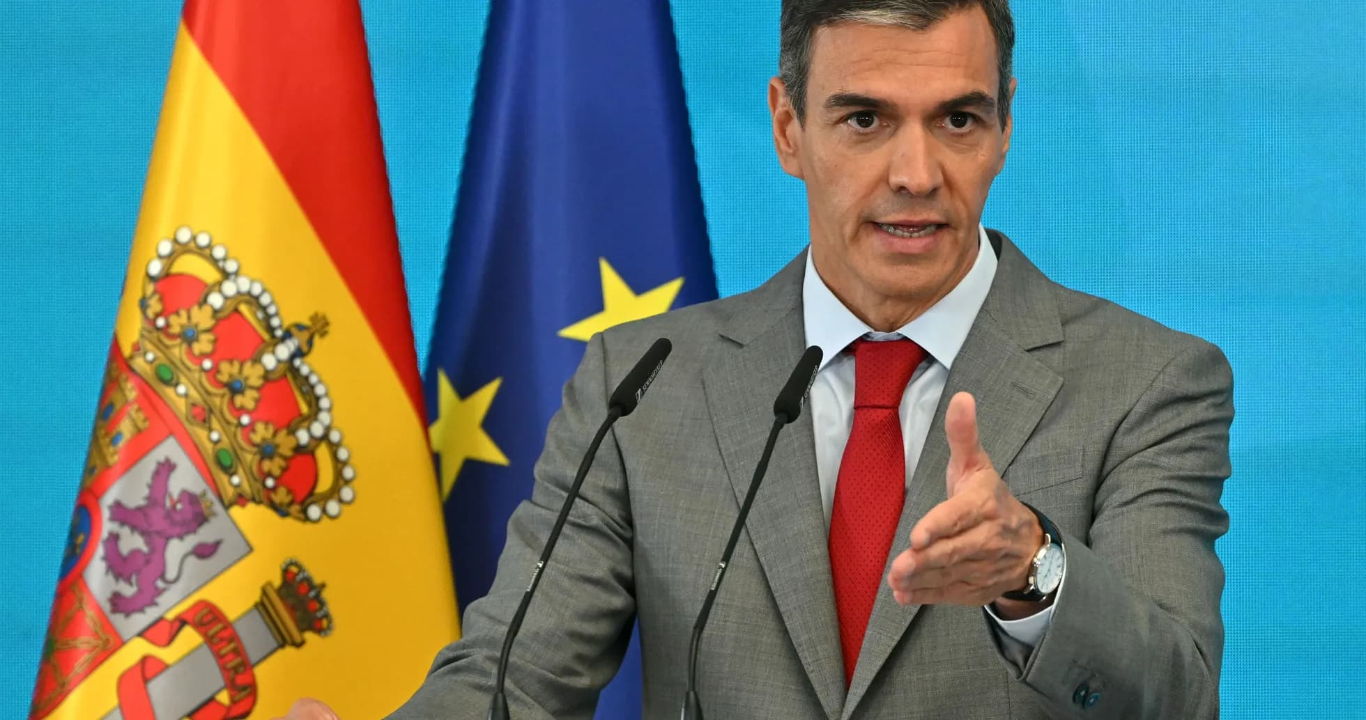 Hombre hablando en un podio con banderas detrás Hombre hablando en un podio con banderas detrás