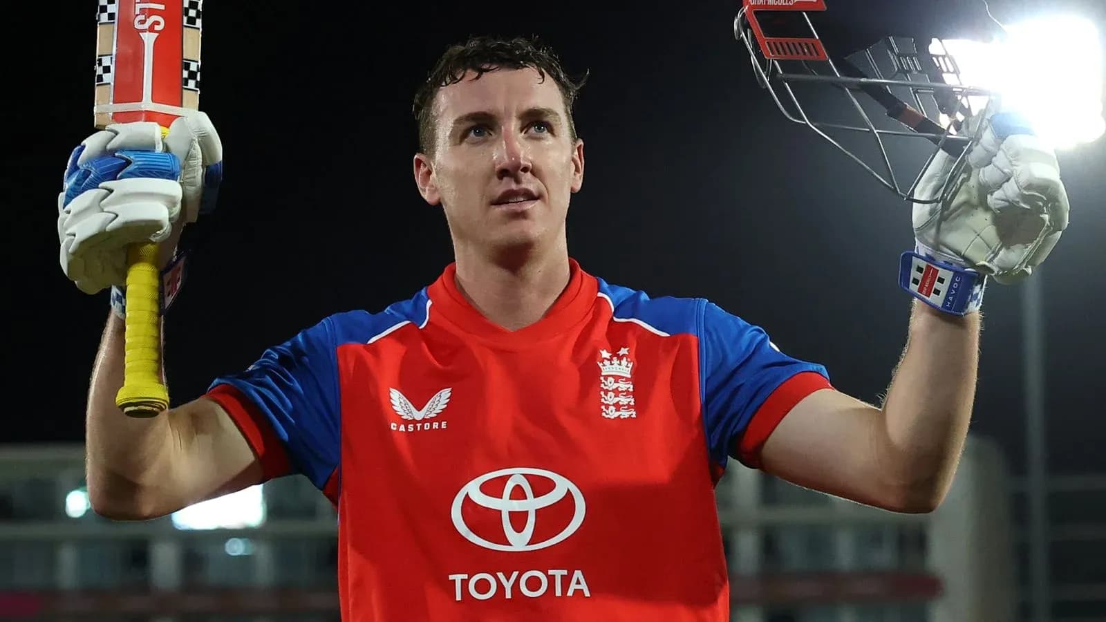 Jugador de cricket levantando su bate tras anotar Jugador de cricket levantando su bate tras anotar