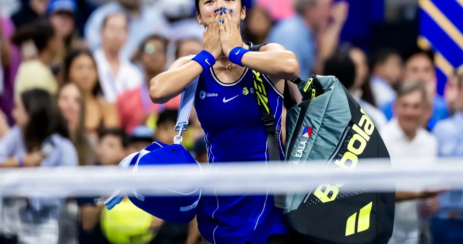 Jugadora de tenis celebrando con mochila en la mano Jugadora de tenis celebrando con mochila en la mano