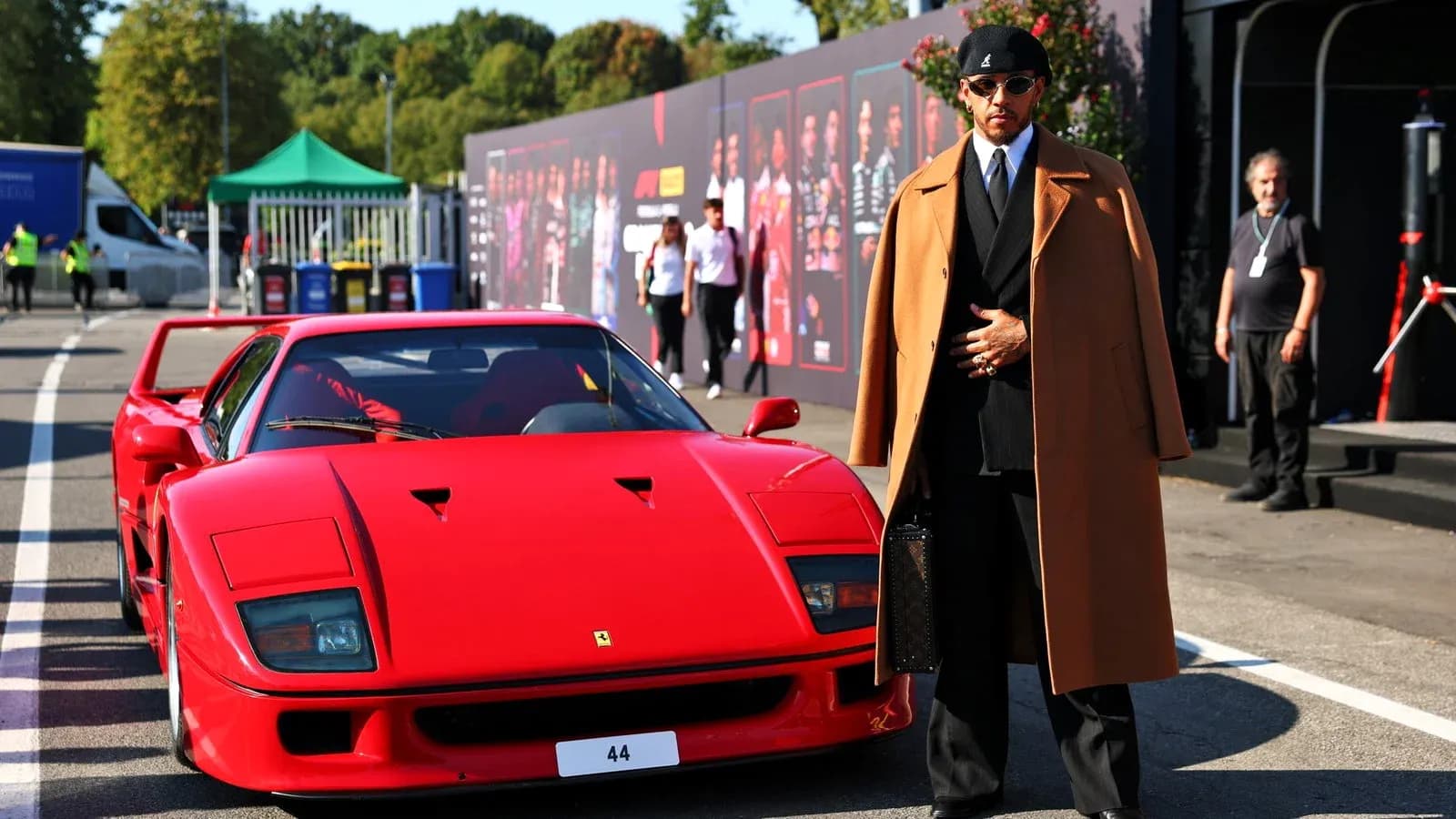 Hombre junto a un Ferrari rojo en evento Hombre junto a un Ferrari rojo en evento
