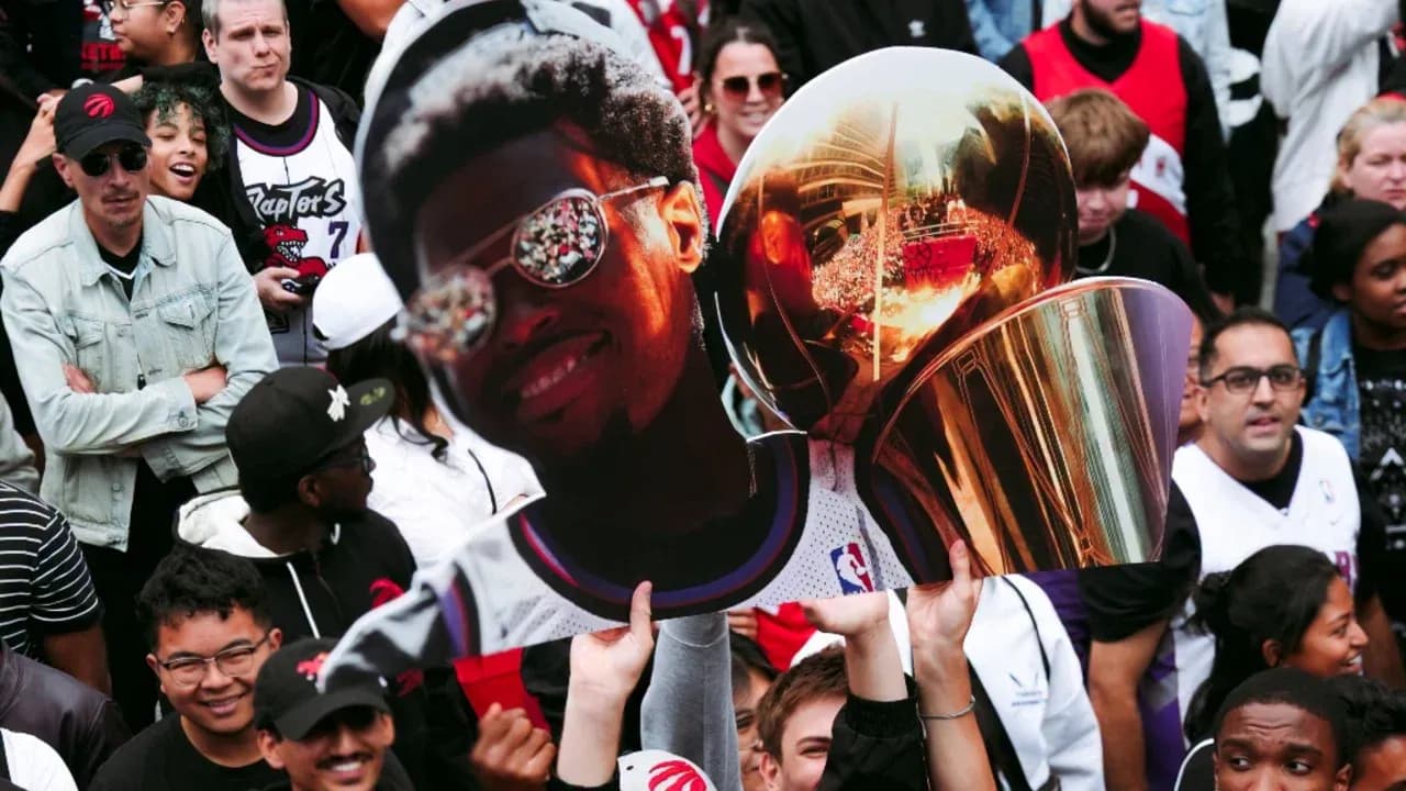 A crowd holding a large cutout of a player A crowd holding a large cutout of a player