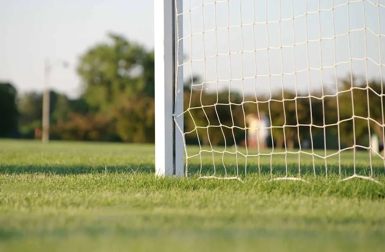 Portería de fútbol con césped y fondo difuso Portería de fútbol con césped y fondo difuso