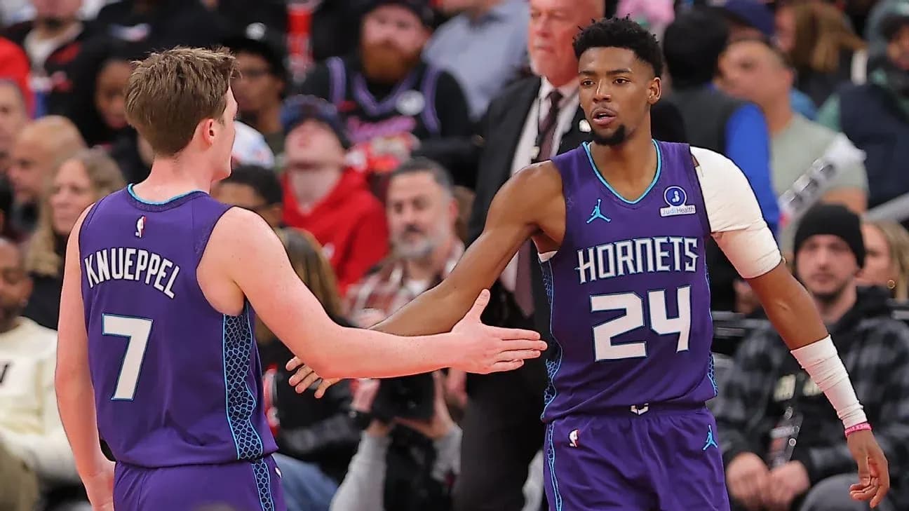 Jugadores de los Hornets chocando manos en la cancha Jugadores de los Hornets chocando manos en la cancha