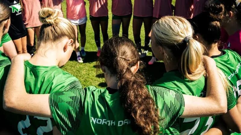 Jugadoras de fútbol en círculo antes del entrenamiento Jugadoras de fútbol en círculo antes del entrenamiento
