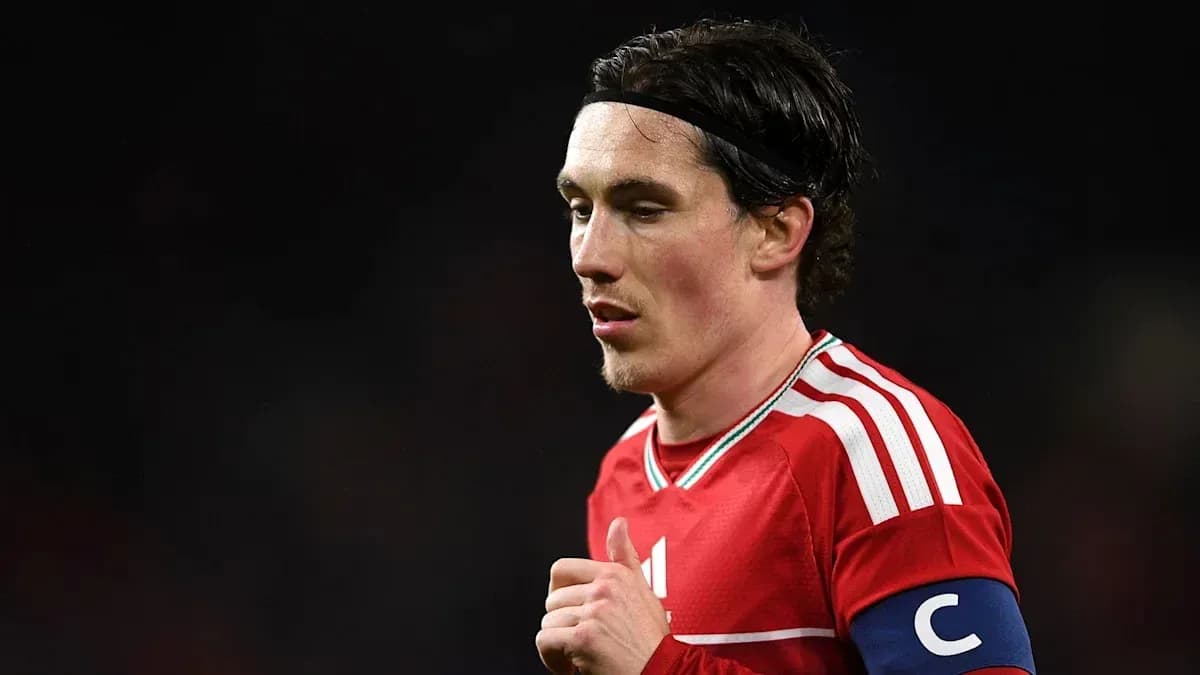 Jugador con cinta de capitán en uniforme rojo Jugador con cinta de capitán en uniforme rojo