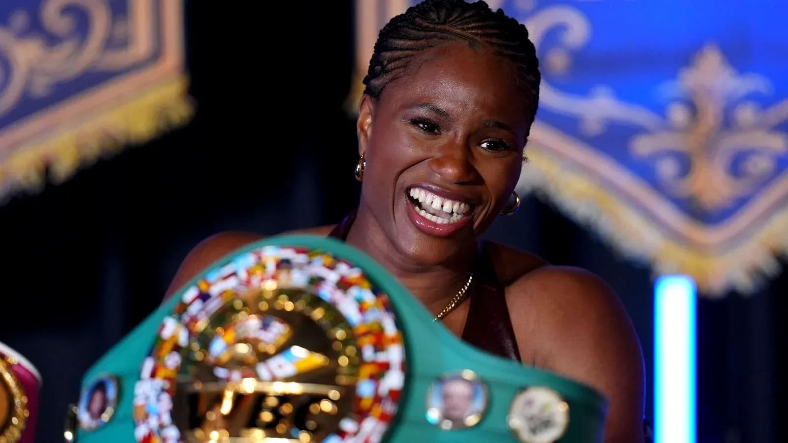 Boxeadora sosteniendo su cinturón de campeón sonriente Boxeadora sosteniendo su cinturón de campeón sonriente