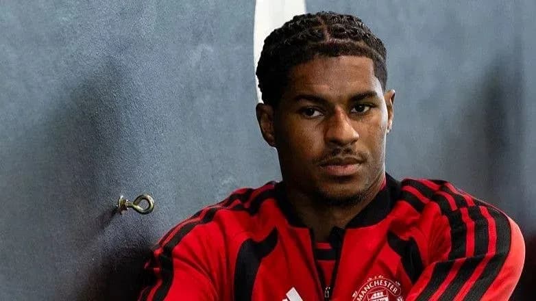 Jugador sentado en vestuario con uniforme de Manchester United Jugador sentado en vestuario con uniforme de Manchester United
