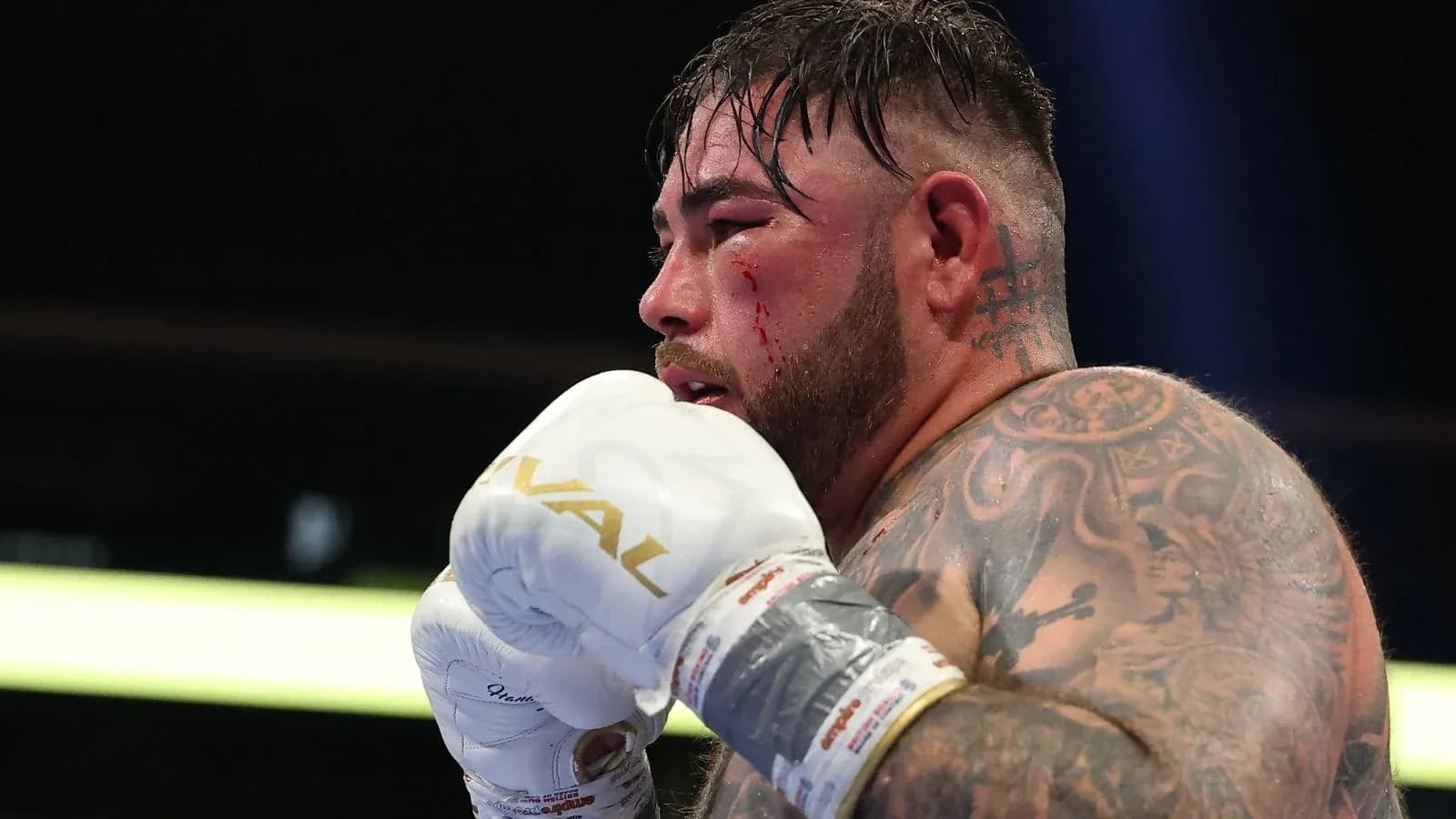 Boxeador con guantes y sangre en el rostro Boxeador con guantes y sangre en el rostro