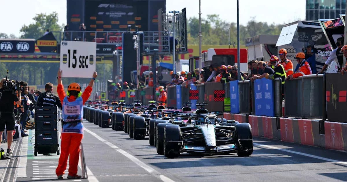 Pilotos de F1 en la parrilla con señal de penalización Pilotos de F1 en la parrilla con señal de penalización