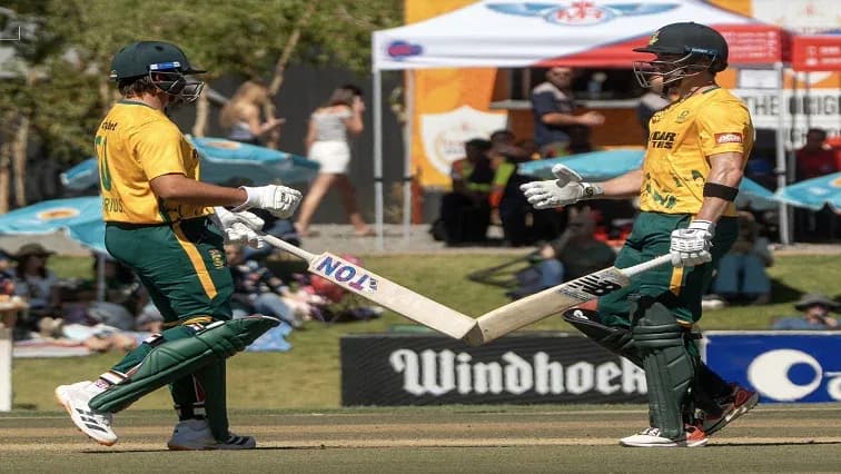 Jugadores de cricket chocando bates en el campo Jugadores de cricket chocando bates en el campo