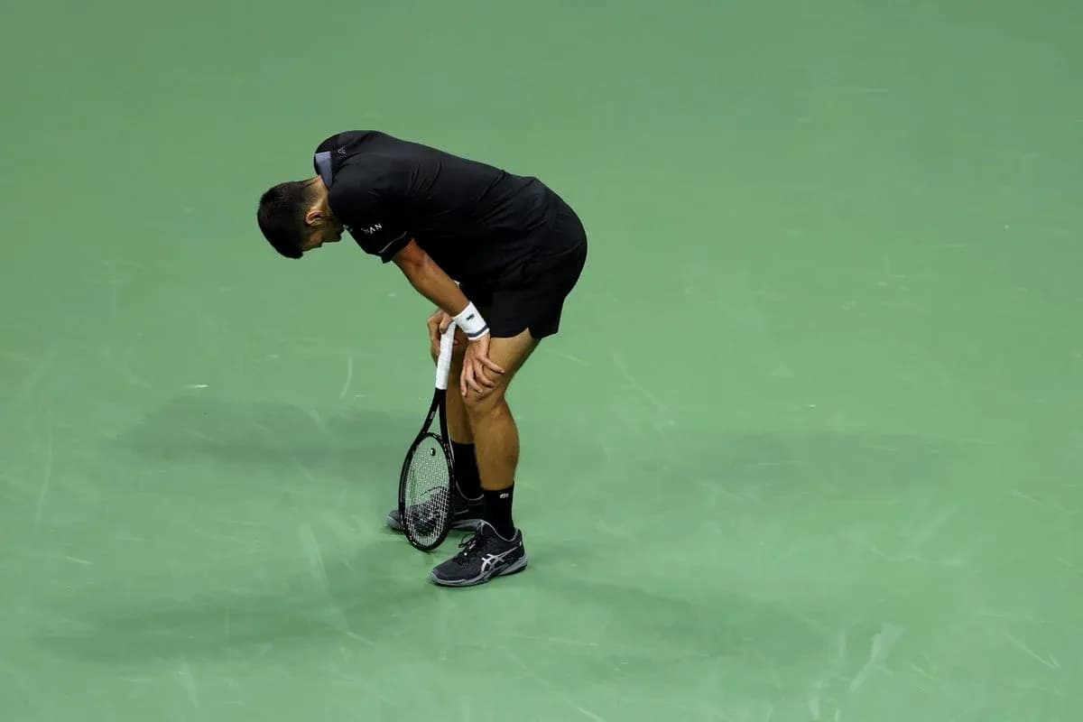 Jugador de tenis agachado en la cancha Jugador de tenis agachado en la cancha