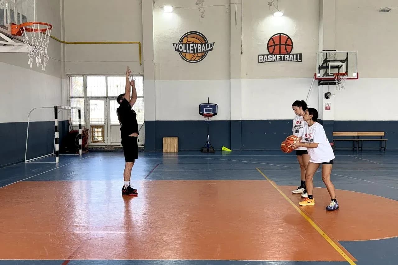 Entrenador enseñando tiro en cancha de baloncesto Entrenador enseñando tiro en cancha de baloncesto