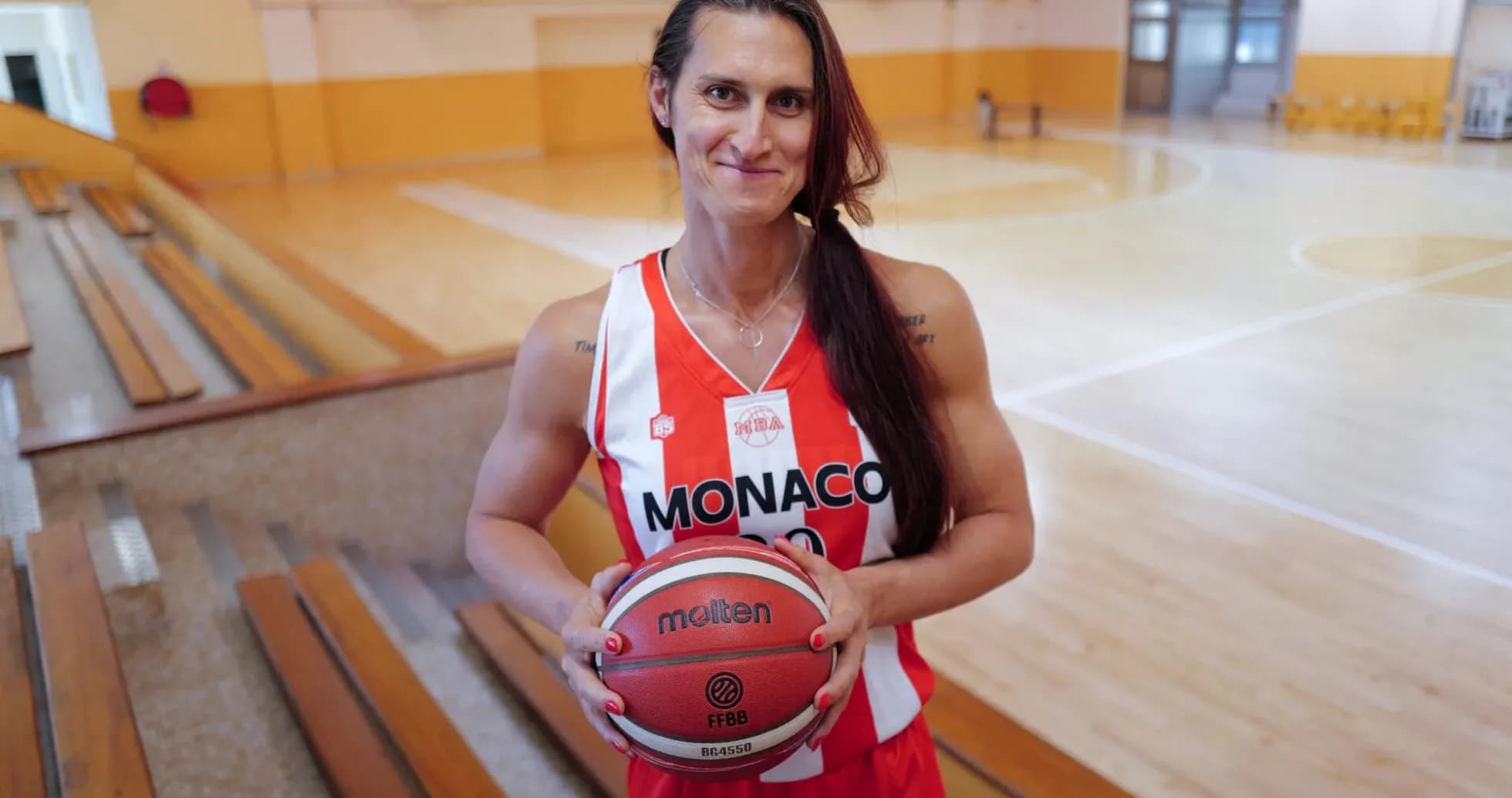 Jugadora de baloncesto sosteniendo un balón en cancha Jugadora de baloncesto sosteniendo un balón en cancha