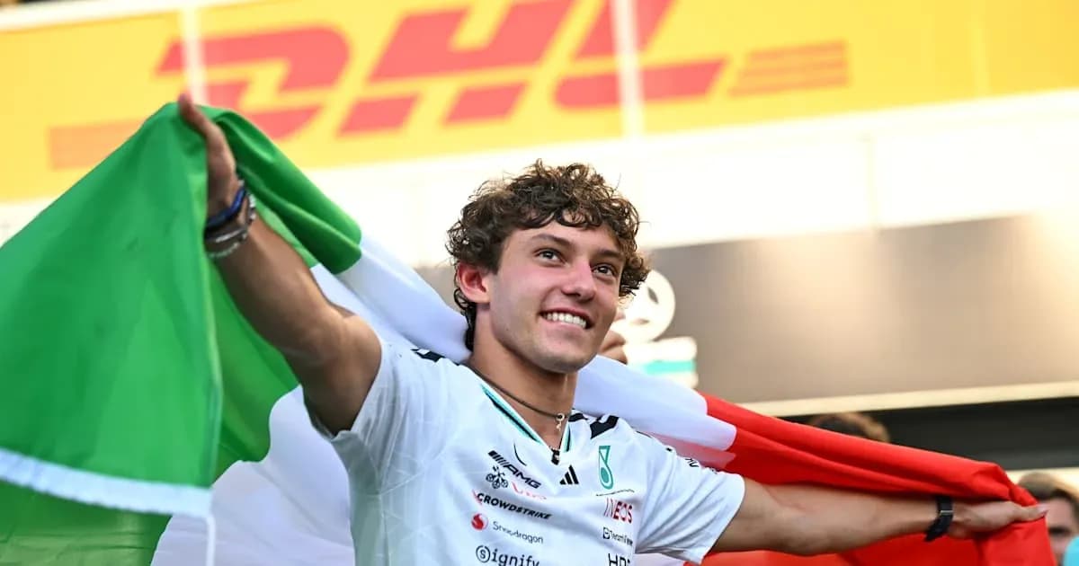 Piloto sosteniendo la bandera italiana en celebración Piloto sosteniendo la bandera italiana en celebración