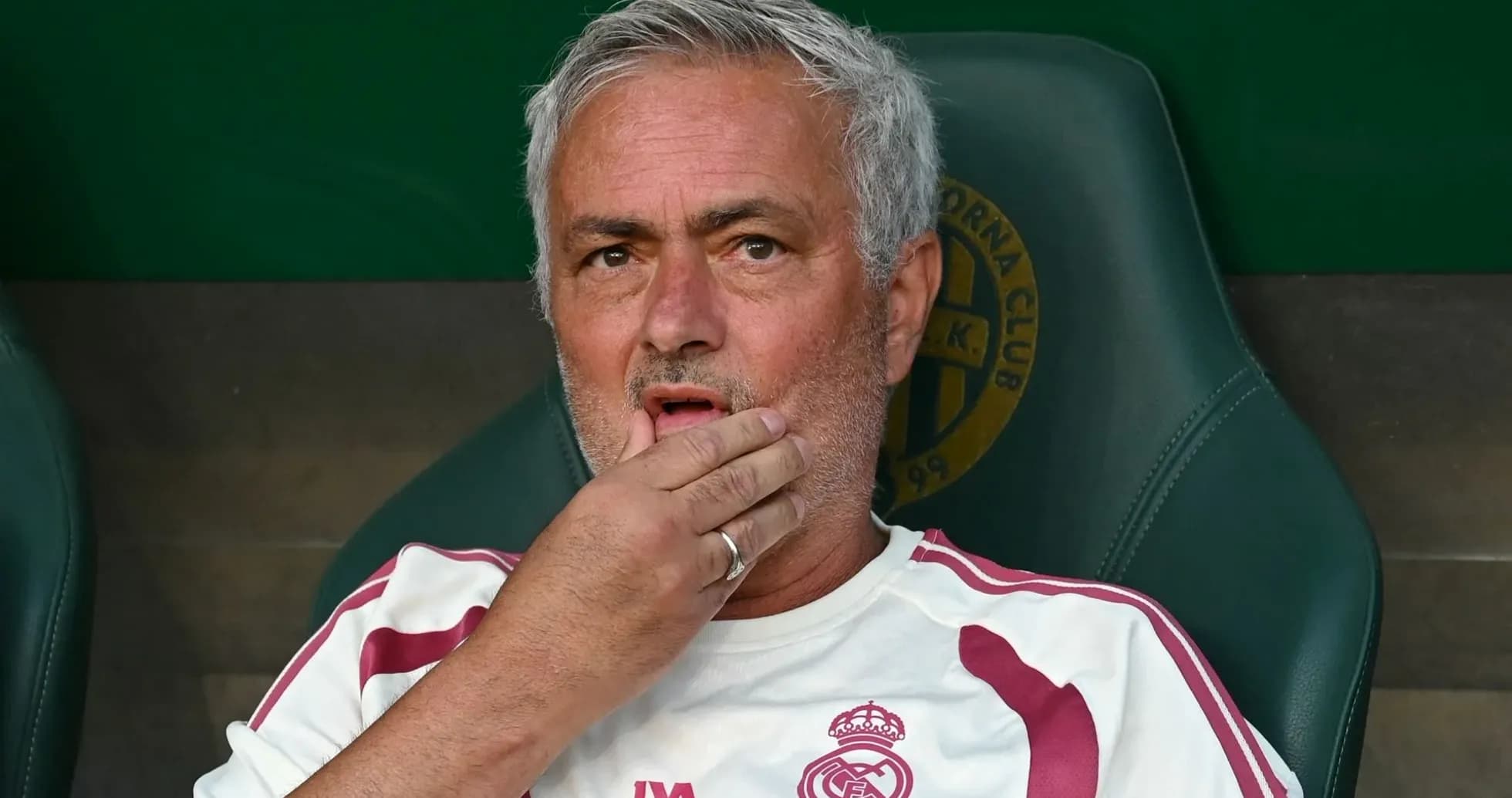 Entrenador sentado en el banquillo con expresión pensativa Entrenador sentado en el banquillo con expresión pensativa